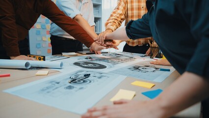 A diverse group of professionals engaged in a collaborative meeting, focusing on project blueprints and ideas, demonstrating teamwork and creativity in a modern office space. SACTR