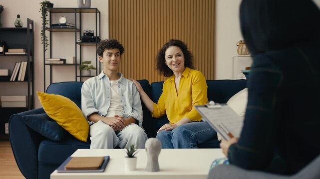 Happy mom and her teen son shaking hands with a psychologist, completing therapy