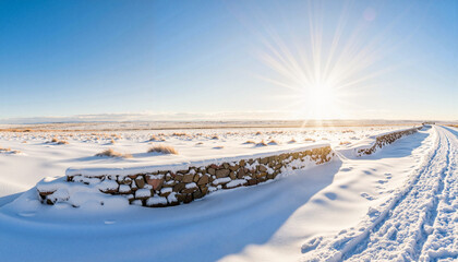 Sunlit snowbank by stone wall in prairie, tranquil winter beauty