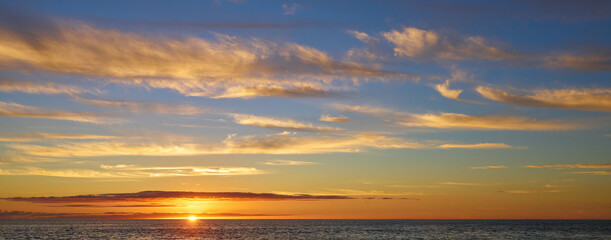 Dramatic Hawaii Sunset over Ocean: Golden Horizon, Majestic Cloudscape, and Warm Tropical Seascape