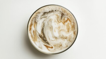 A top-down view of an iced latte in a clear glass, showcasing the layers of espresso and milk swirling together over ice