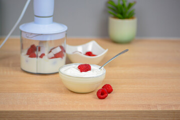 Blender with yogurt and berries, concept of diet and healthy food