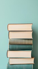 Stack of books against teal wall; education, reading, knowledge
