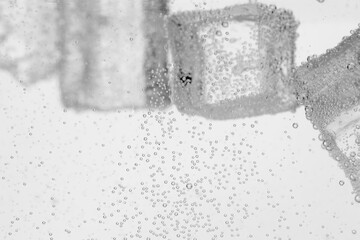 Refreshing soda water with ice cubes as background, closeup
