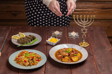 Hands of a Jewish woman making a blessing on candles on the eve of Shabbat in candlesticks