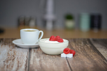 white yogurt on the table with raspberries close-up, healthy breakfast in the kitchen