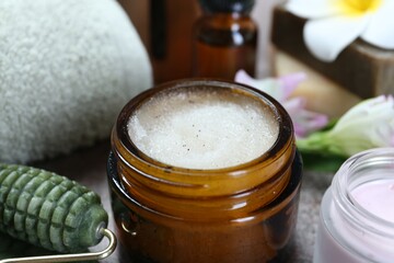 Body care products in jars and face roller on table, closeup
