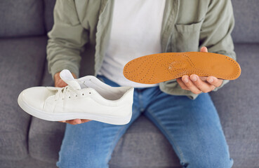Close up shot of a man inserting an insole into shoe. Health conscious action related to...