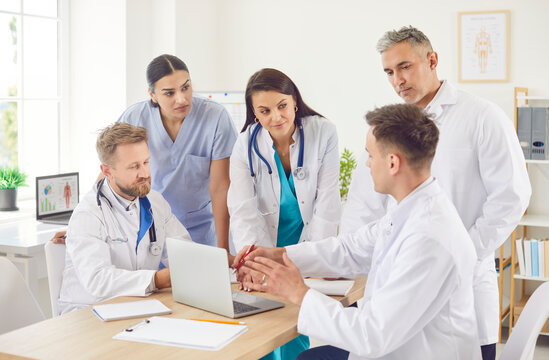 Group of doctors and nurses holds a meeting or conference in the hospital, utilizing a laptop for healthcare discussions and medical planning. Teamwork and commitment to healthcare. - Powered by Adobe