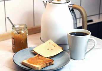 Modern toaster and tasty breakfast on kitchen table with fresh toast bread and jam.
