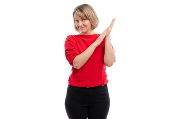 A young woman in a red sweater clapping her hands with a cheerful expression against a white...