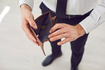 Open empty purse closeup of unemployed man holding empty leather wallet feeling poor, bad stressed...