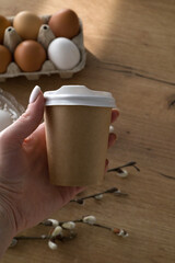Paper cup with a plastic lid Easter theme, on the background of Easter eggs