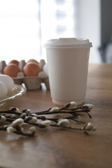 Paper cup with a plastic lid Easter theme, on the background of Easter eggs