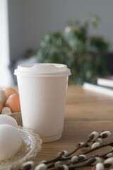 Paper cup with a plastic lid Easter theme, on the background of Easter eggs