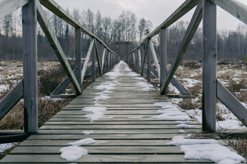 Fototapeta premium Long Wooden Pathway Across a Frozen Landscape