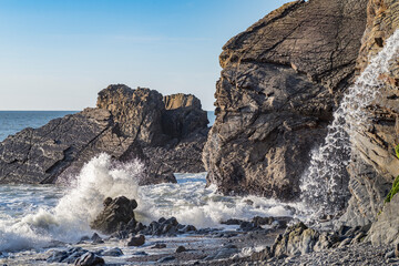 Rocks and waterfall at high tide Sandymouth Bay