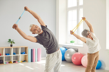 Senior health care rehabilitation, doing side bend exercise with rubber band, to help elderly in...