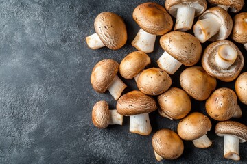 Fototapeta premium Delicious brown mushrooms scattered over a dark rough textured surface
