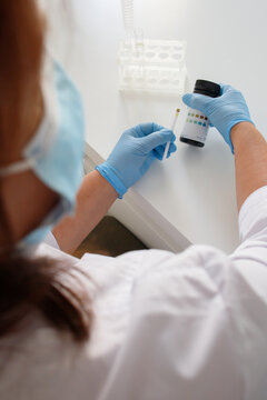 Medical laboratory nurse checking the glucose levels in urine using express strips