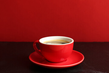 Red cup with coffee on black table