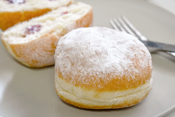German jam doughnut. Krapfen or Berliner with jam filling on a plate.