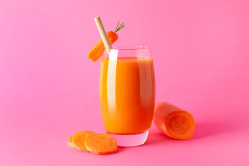 Fresh carrot smoothie in glass and cut vegetable on pink background, closeup