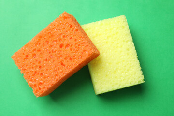 Soft sponges on green background, top view. Cleaning tool