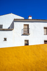 White and Yellow House Facade in Carratraca, Malaga, Andalusia, Spain