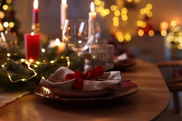 Festive table setting in room decorated for Christmas, closeup. Bokeh effect © New Africa