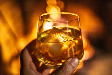 Whisky on the rocks by the fireplace creates a cozy atmosphere