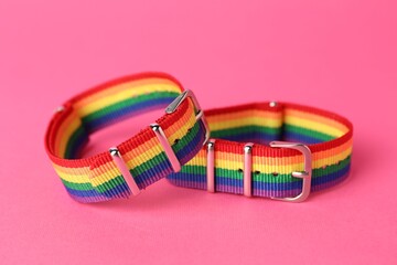 Two wristbands in LGBT colors on pink background, closeup