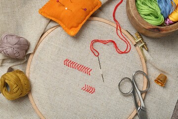 Embroidery and different sewing accessories on table, flat lay