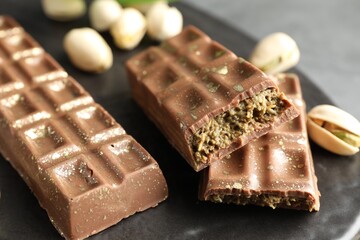Delicious Dubai chocolate bars and pistachios on table, closeup