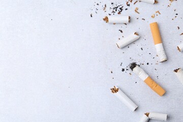 Many cigarette butts on light gray background, flat lay. Space for text