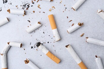 Many cigarette butts on light gray background, flat lay