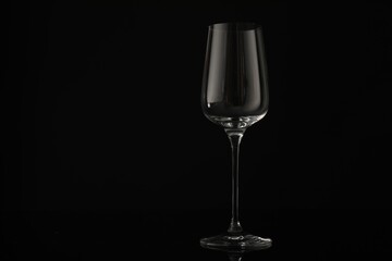 One empty clean glass on black background. Space for text
