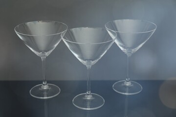 Three empty clean glasses on grey background