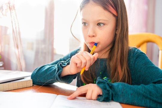 Schoolgirl Deep in Thought While Doing Her Homework