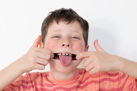Boy showing his first missing milk tooth with joy