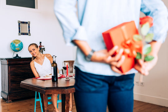 Romantic surprise with a gift and rose on a dinner date