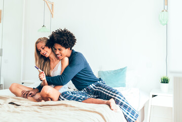 Couple Joyfully Celebrating Positive Pregnancy Test in Bedroom