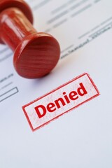Red stamp marked "Denied" prominently displayed on document, con