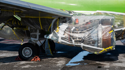 An airplane turbine undergoing repairs is wrapped in film. 