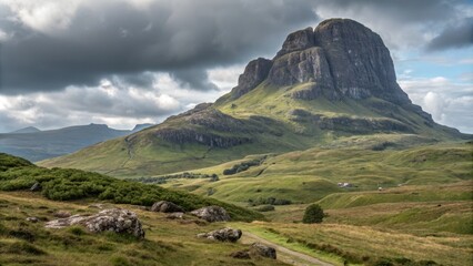 Fototapeta premium Dramatic Landscape of the Old Man of Storr, Skye, Scotland Wide Shot Composition, Cloudy Sky, Rugged Mountain, Grassy Hills, Path.