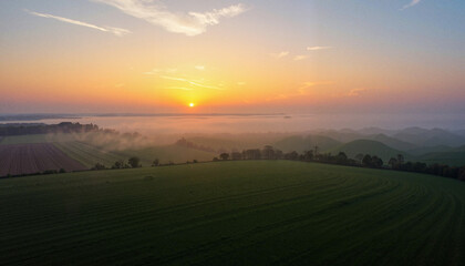Fototapeta premium Glowing horizon at dawn over empty farmland, peaceful beginnings
