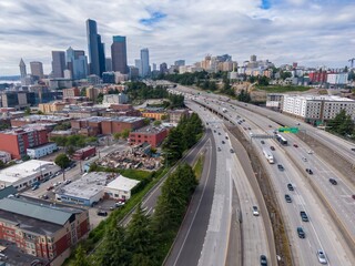 Naklejka premium Seattle highway traffic, city skyline, and demolition site. Aerial view of I-90, cars, trucks, and Seattle's urban landscape. Construction and urban renewal. Washington, USA