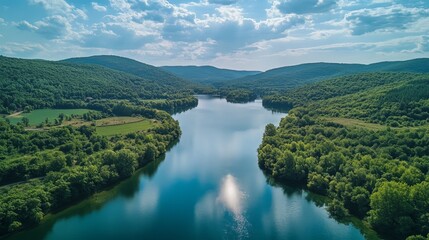 Naklejka premium Scenic river journey through lush green hills serene nature landscape aerial view tranquil environment
