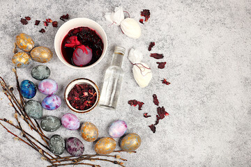 Recipe for dyeing Easter eggs with natural hibiscus tea and curcumin, with a willow branch on a concrete background. Easter celebration concept, holiday card and ideas for preparing 