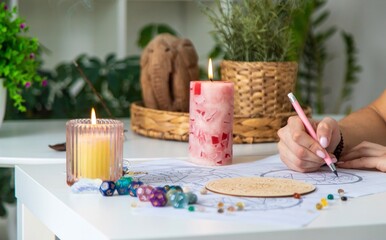 Woman astrologer draws a natal chart. Selective focus
